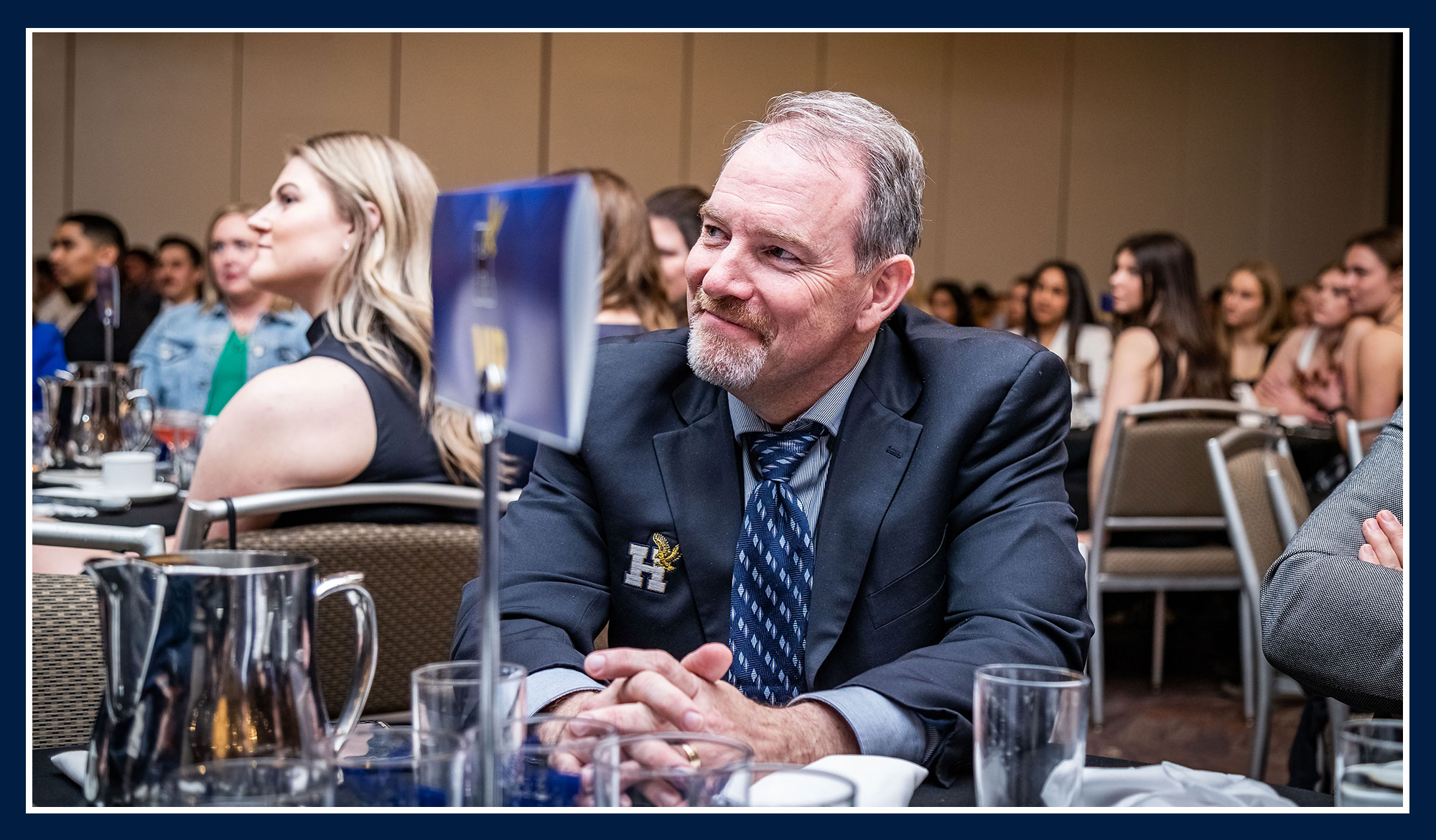 Ray sitting at a table watching the awards banquet
